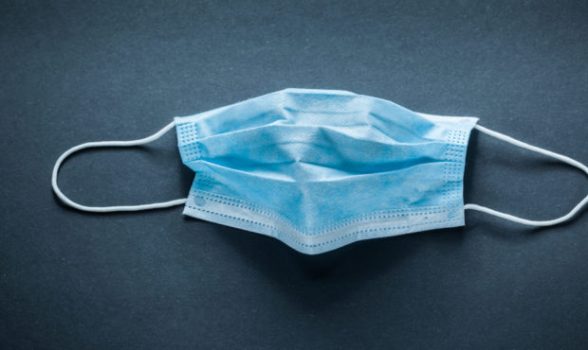 Disposable surgical mask on black background